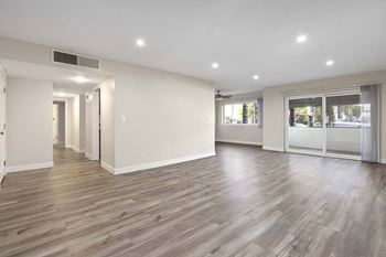 A renovated living room with white walls and wood flooring